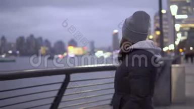 一个穿着黑色夹克和帽子的年轻女孩看着瓦伊坦海滨的上海景色